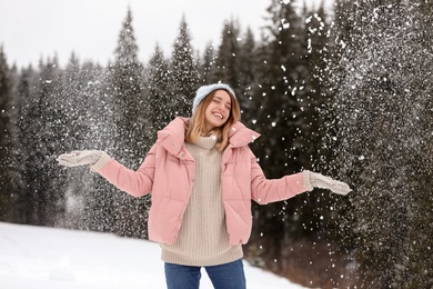 Photo of Young woman in warm clothes outdoors on snowy day. Winter vacation