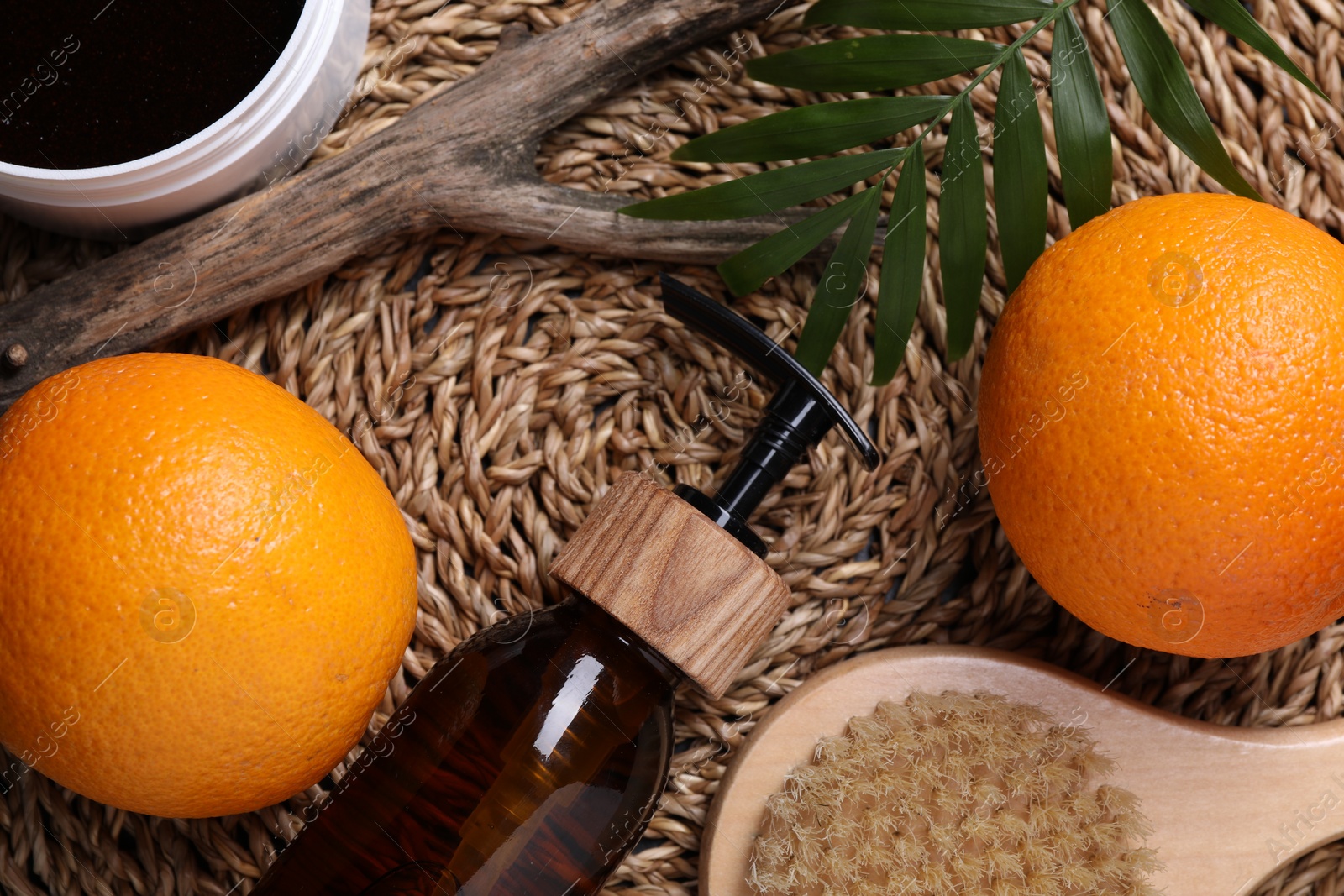 Photo of Flat lay composition with bottle of cosmetic product and oranges on wicker surface. Cellulite treatment