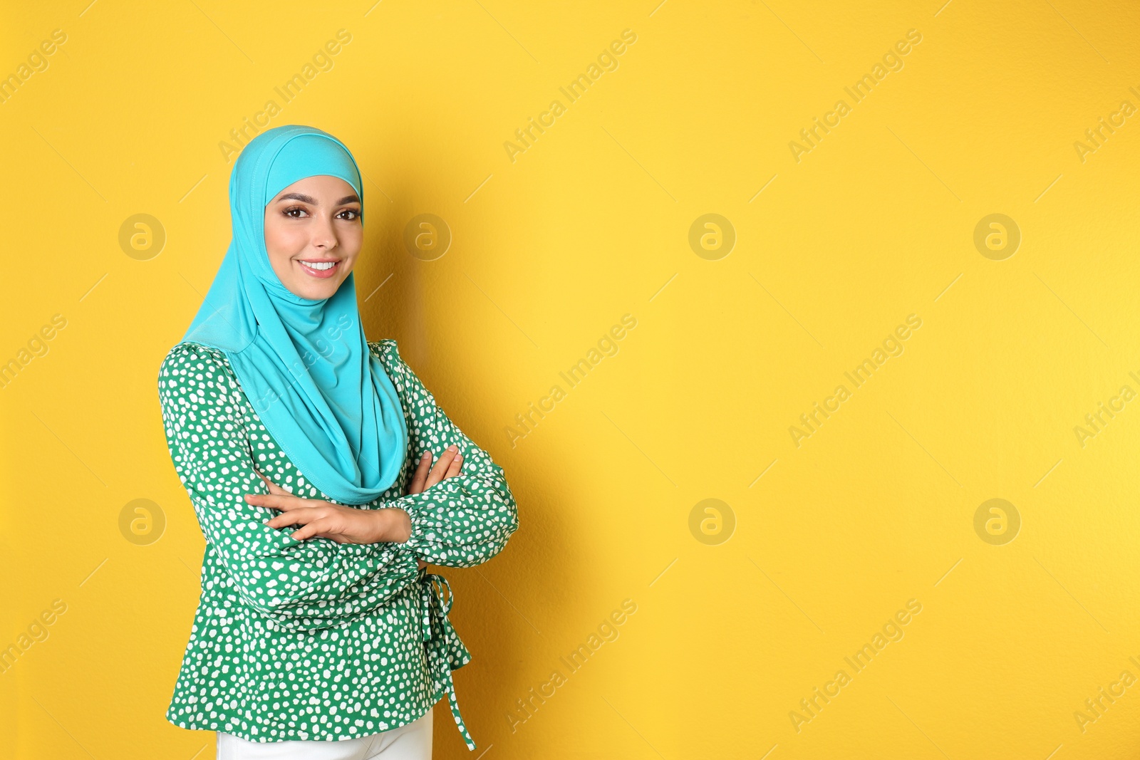 Photo of Portrait of young Muslim woman in hijab against color background. Space for text