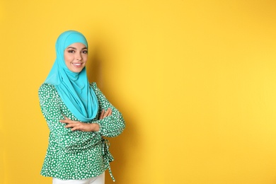 Portrait of young Muslim woman in hijab against color background. Space for text