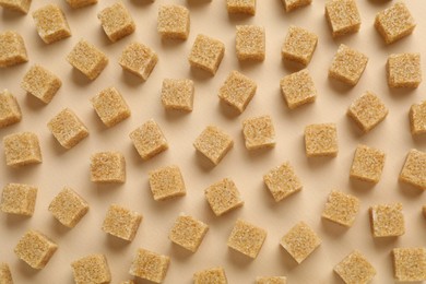 Photo of Brown sugar cubes on beige background, top view