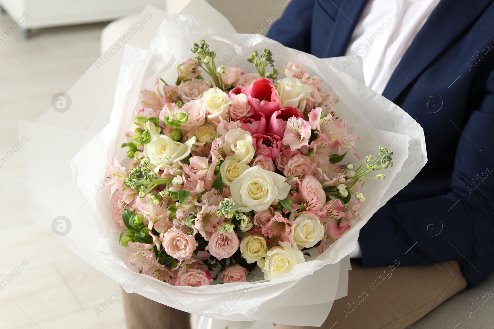 Photo of Man with beautiful bouquet of flowers indoors, closeup