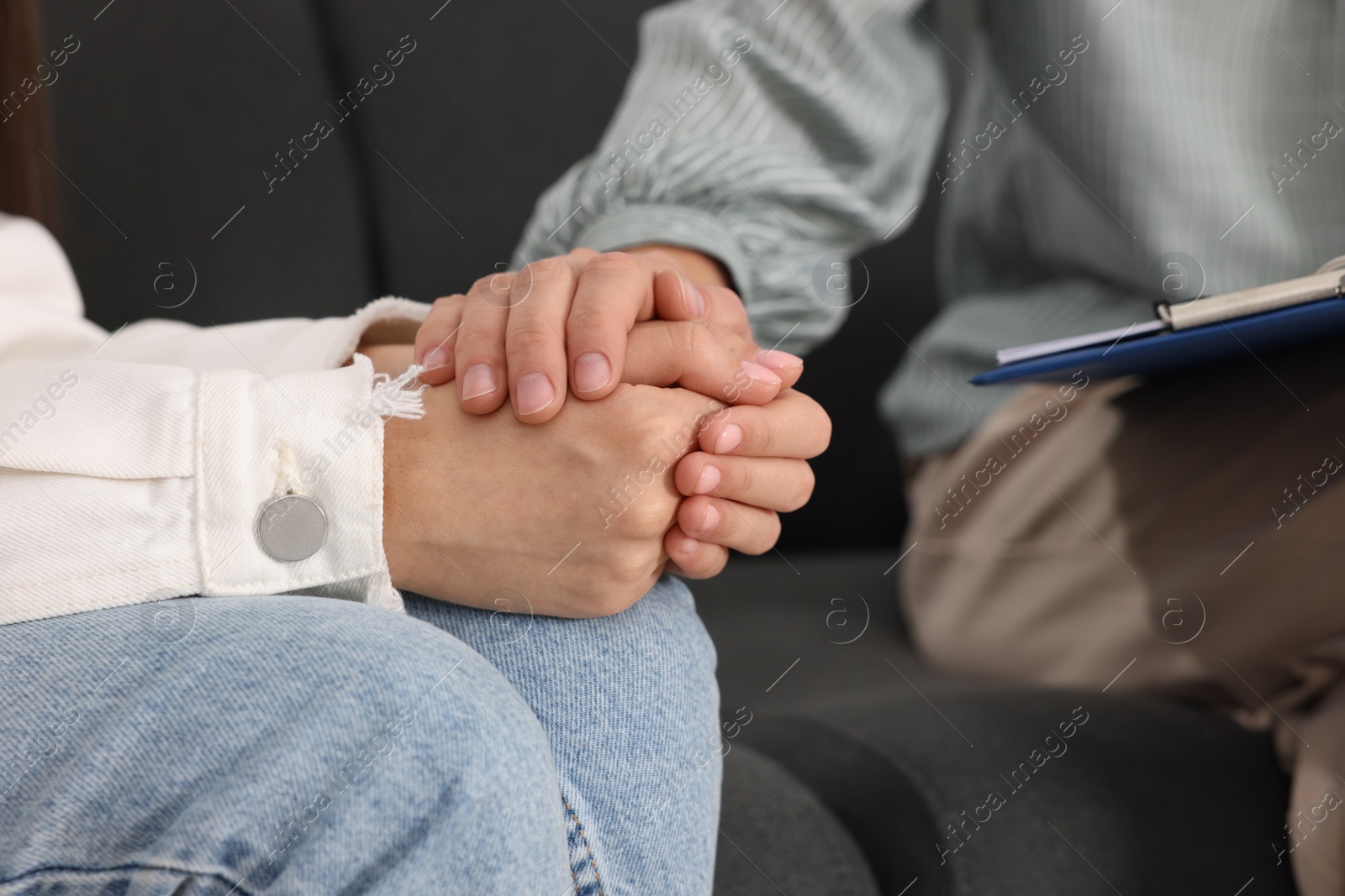 Photo of Psychologist working with teenage girl on sofa, closeup. Teenager problems