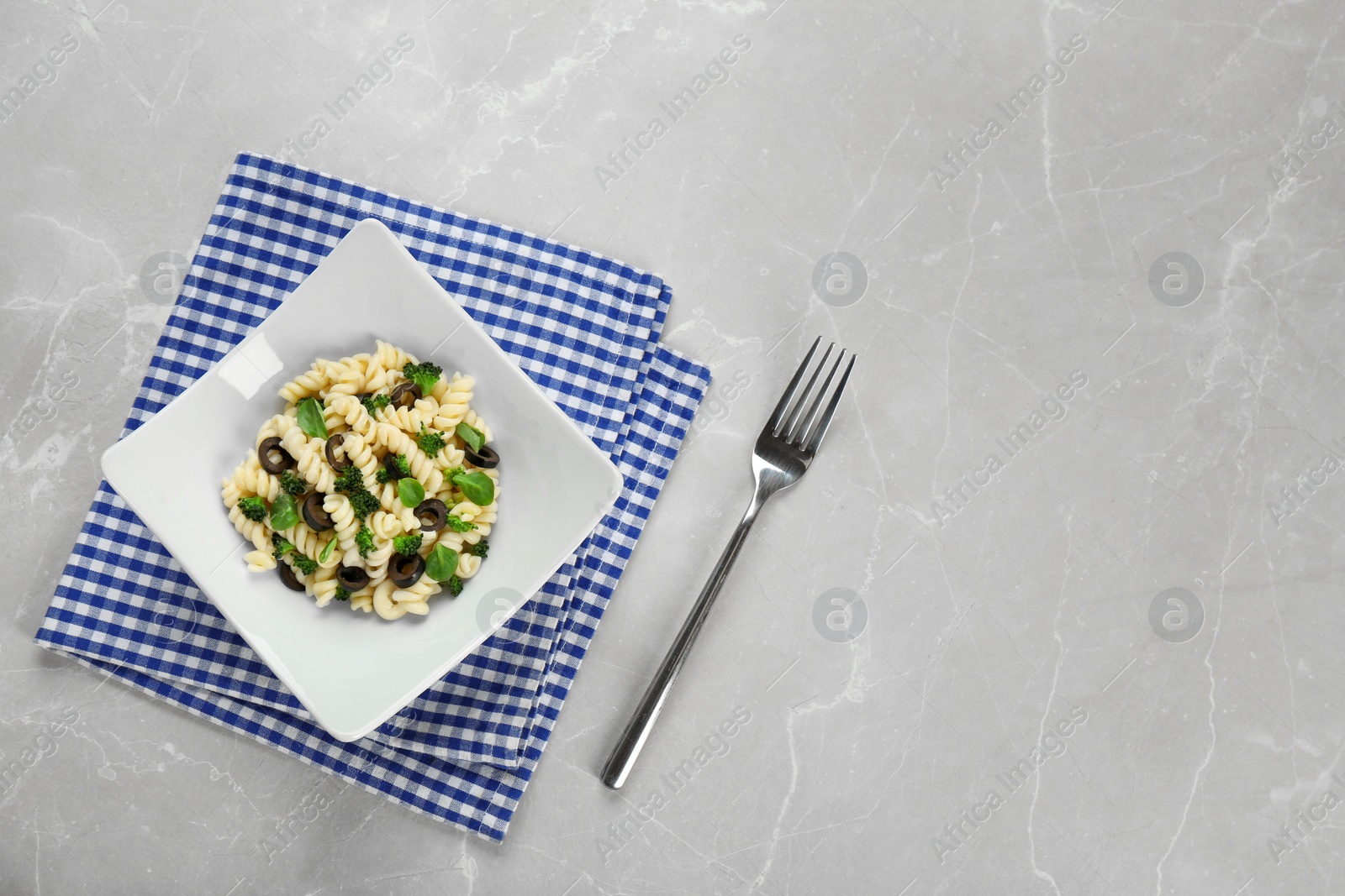 Photo of Tasty pasta salad with black olives  on table