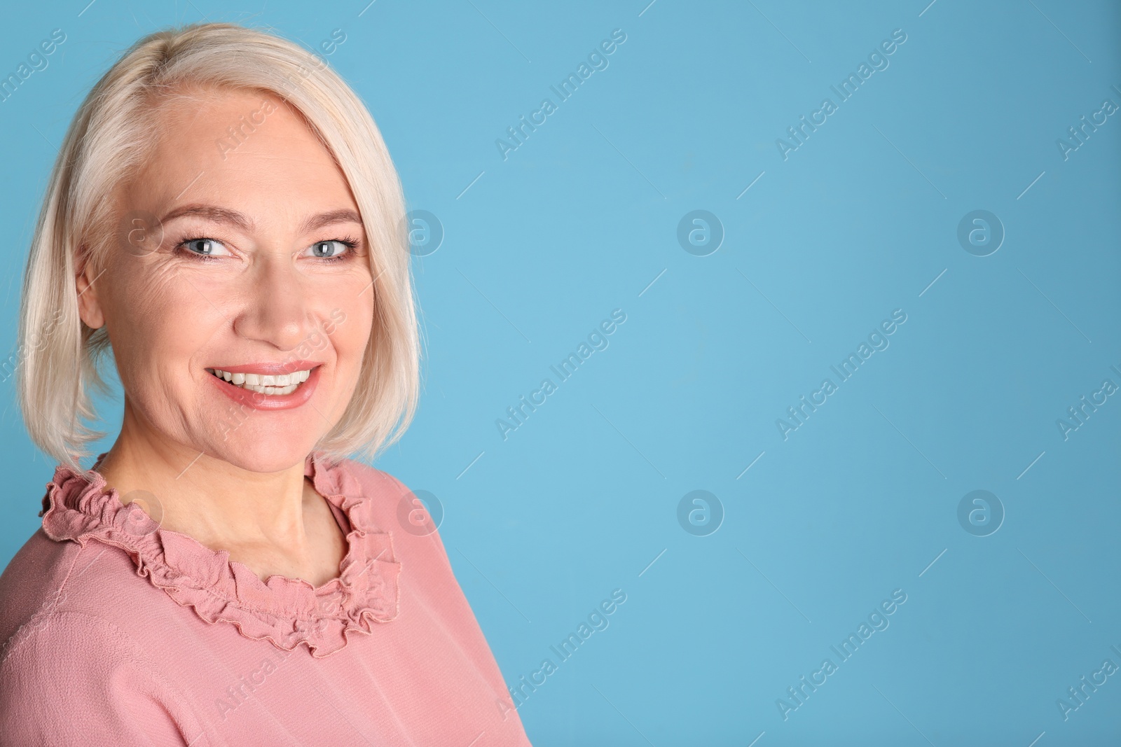 Photo of Portrait of charming mature woman with healthy beautiful face skin and natural makeup on blue background, space for text
