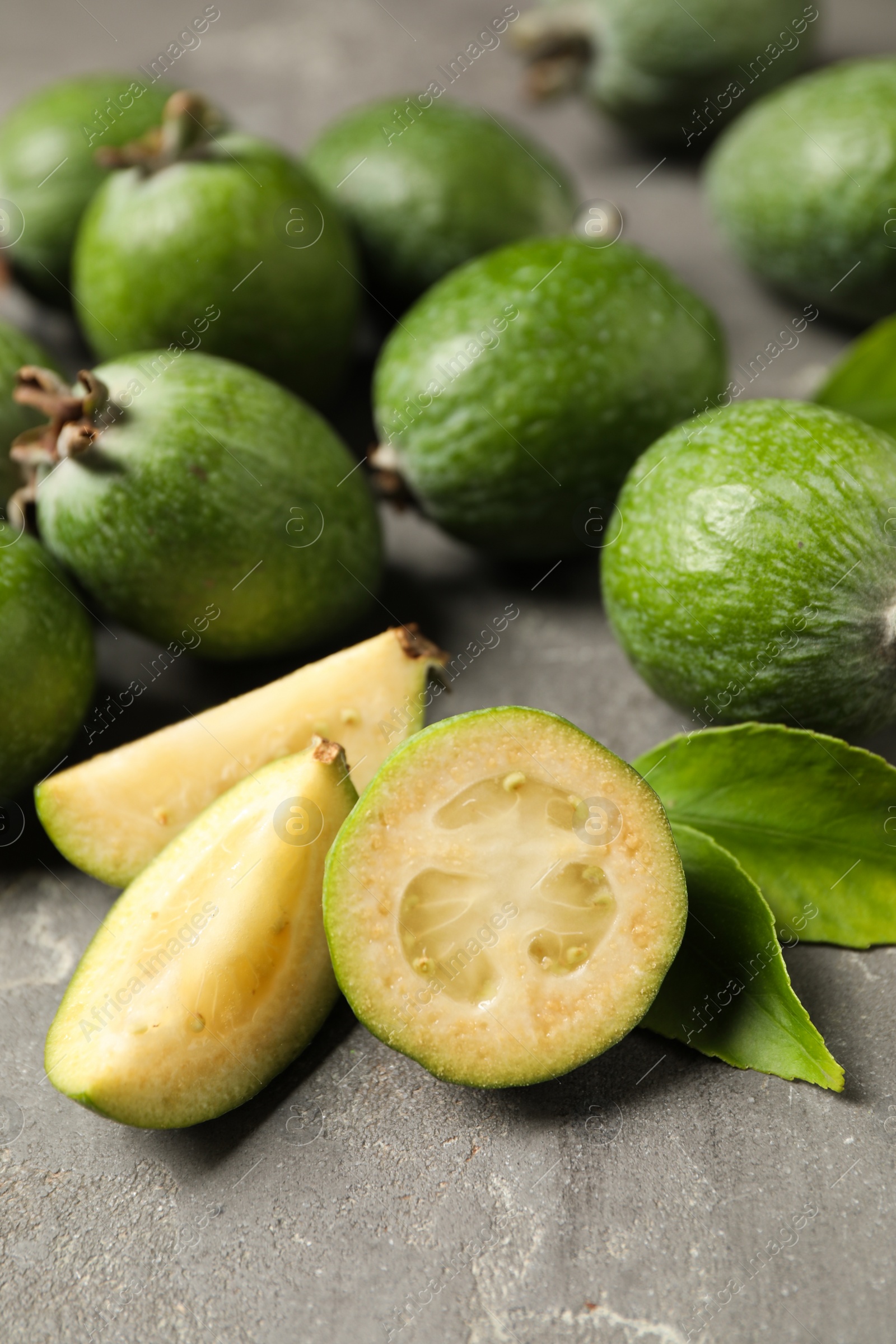 Photo of Fresh green feijoa fruits on grey table, closeup