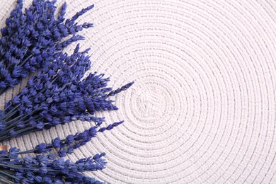Photo of Bouquets of beautiful preserved lavender flowers on white cotton place mat, top view. Space for text