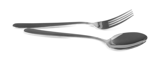 Shiny fork and spoon on white background