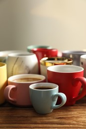 Photo of Many cups of different coffees on wooden table