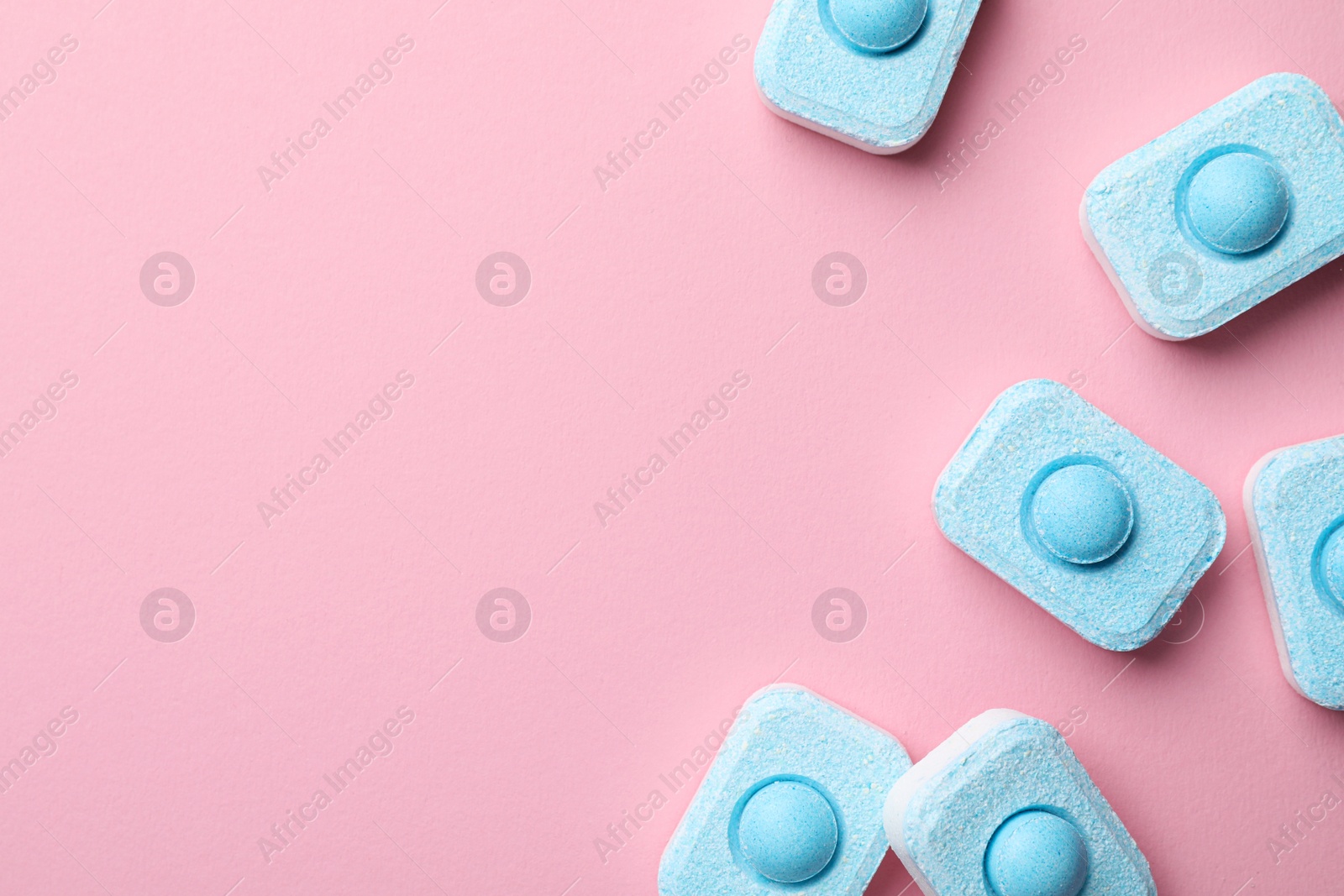 Photo of Water softener tablets on pink background, flat lay. Space for text