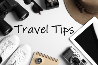 Image of Flat lay composition with tablet, binoculars and camera on white background. Travel Tips