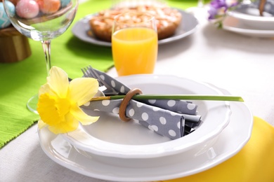 Photo of Festive Easter table setting with flower, closeup view