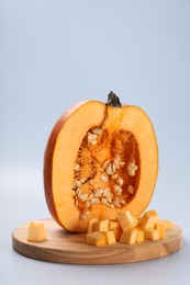 Photo of Cut fresh ripe pumpkin on light background