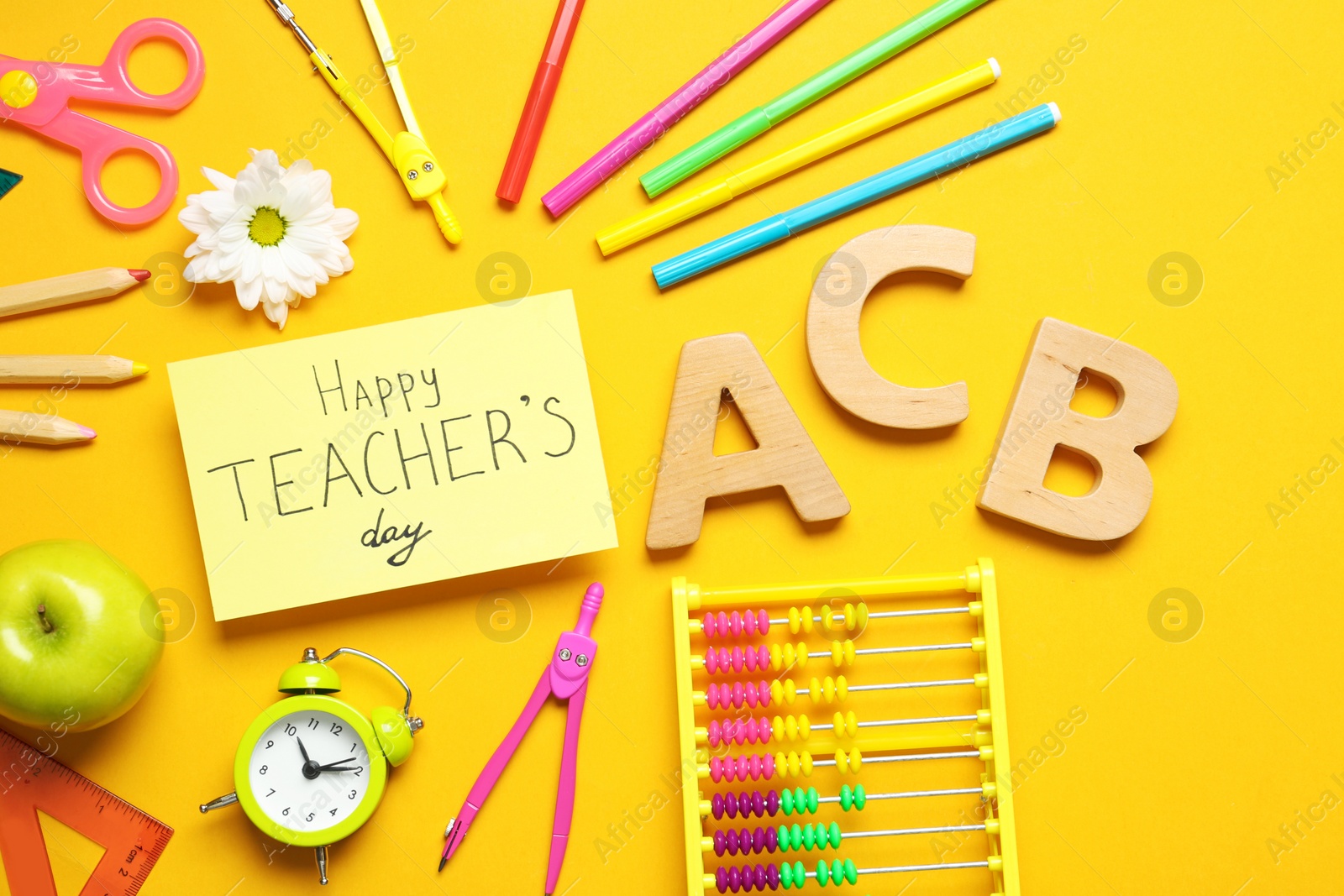 Photo of Flat lay composition of card with inscription HAPPY TEACHER'S DAY and stationery on orange background