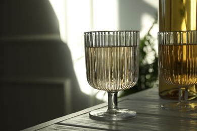 Alcohol drink in glasses on wooden table indoors, closeup. Space for text