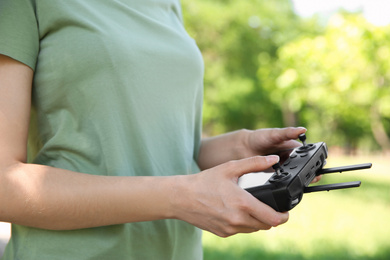 Woman holding new modern drone controller outdoors, closeup of hands