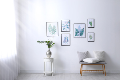 Photo of Beautiful paintingstropical leaves on white wall in living room interior