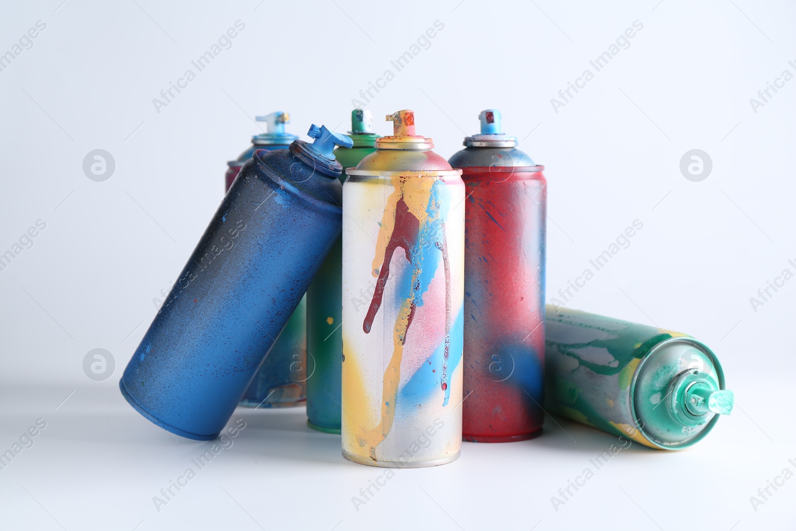 Photo of Many spray paint cans on white background