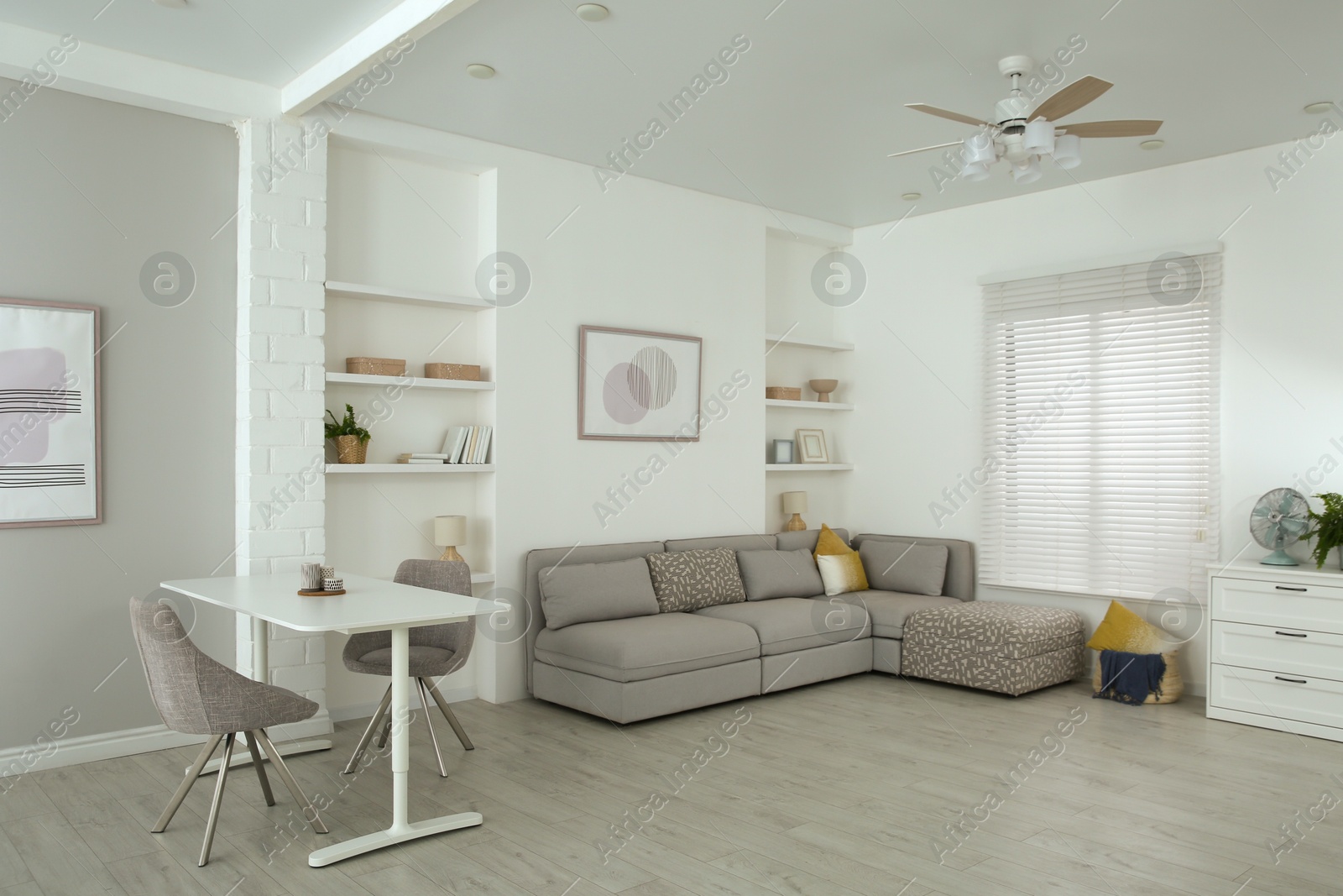 Photo of Comfortable furniture, ceiling fan and accessories in stylish living room