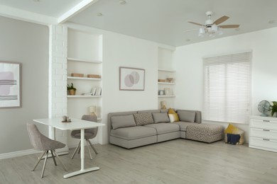 Comfortable furniture, ceiling fan and accessories in stylish living room