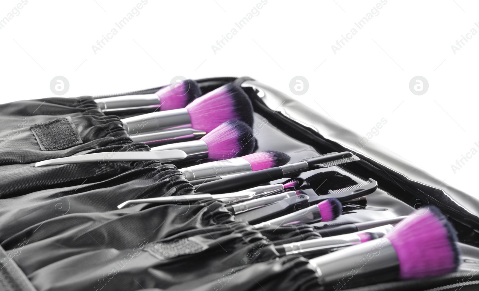 Photo of Stylish case with tweezers and brushes for applying makeup products on white background, closeup