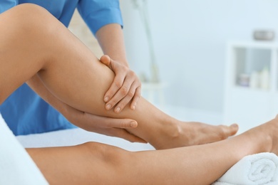 Photo of Woman receiving leg massage in wellness center, closeup