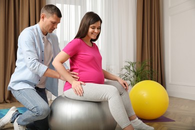 Photo of Young pregnant woman with husband in gym