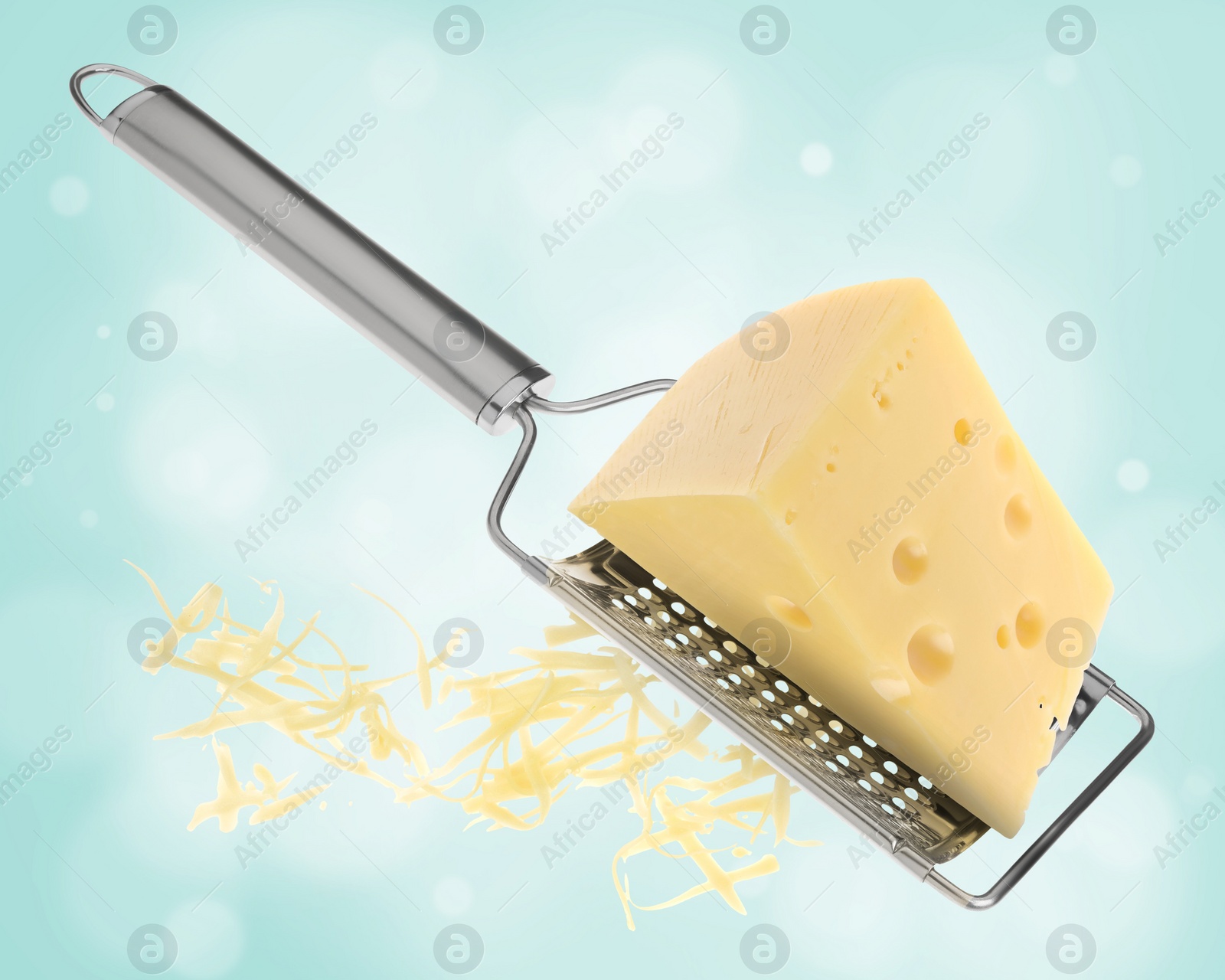 Image of Grating cheese with hand grater on turquoise background