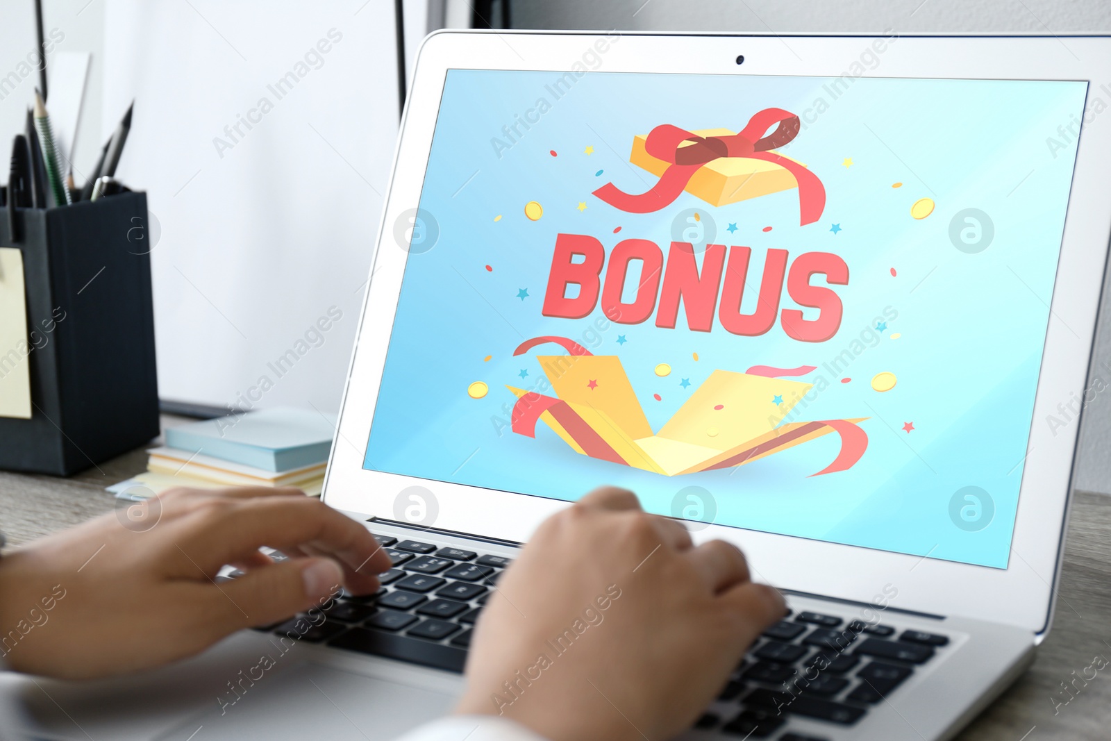 Image of Bonus gaining. Woman using laptop with at table, closeup. Illustration of open gift box, word and confetti on device screen