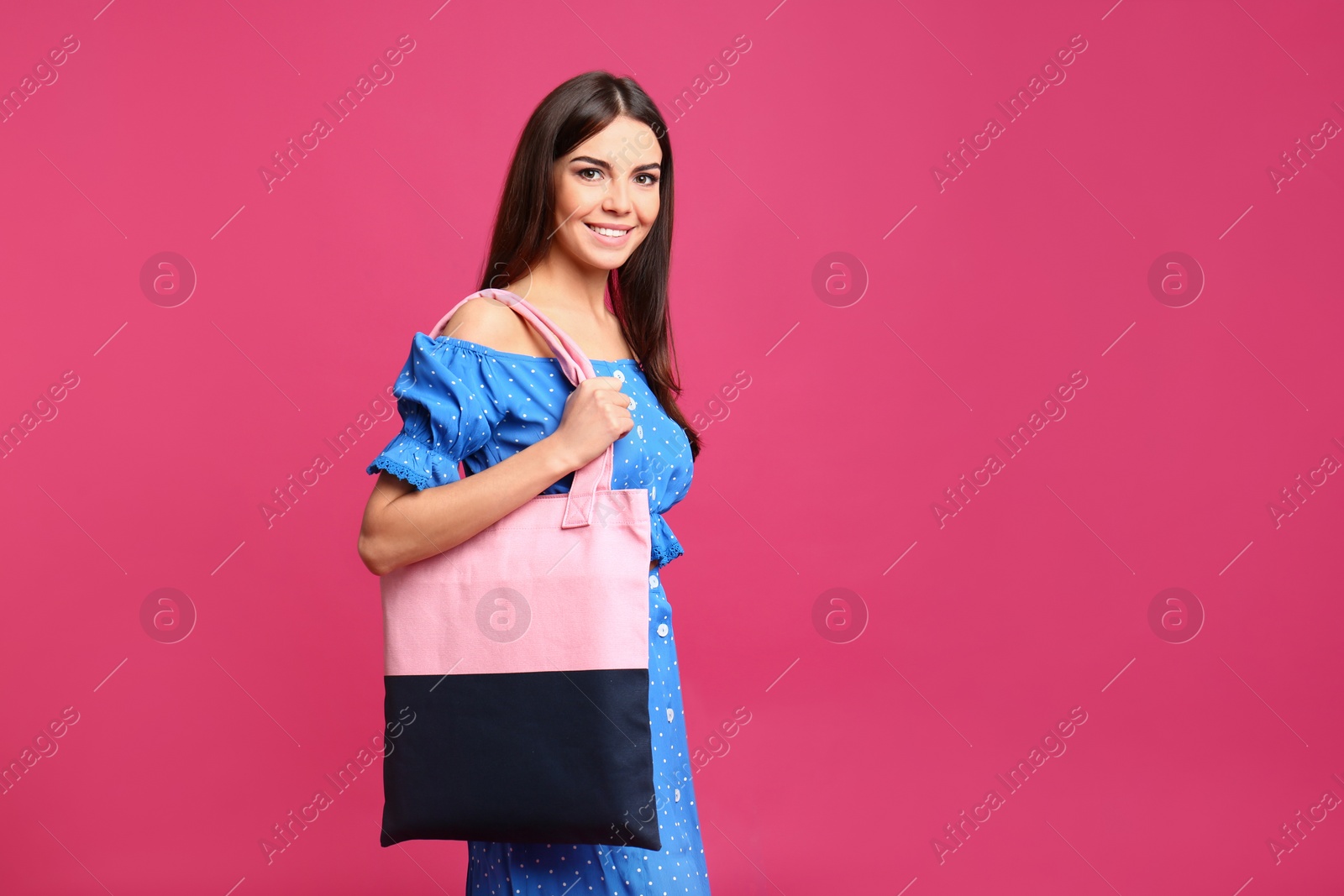 Photo of Portrait of young woman with textile bag on pink background. Space for text