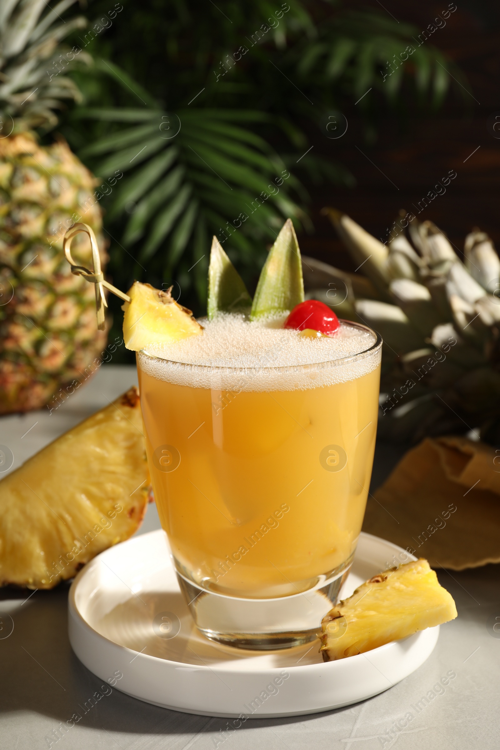 Photo of Tasty pineapple cocktail and fresh fruit on light grey table