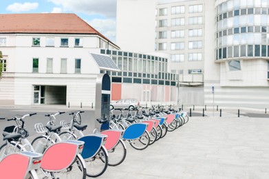 Photo of Many bicycles and station on city street. Bike rental fleet