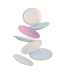 Image of Many different plates falling on white background