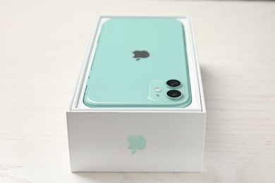 Photo of MYKOLAIV, UKRAINE - JULY 10, 2020: New modern Iphone 11 Green in original box on white wooden table