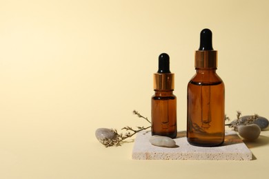 Photo of Composition with bottles of cosmetic serum on beige background. Space for text