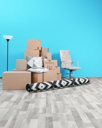 Photo of Cardboard boxes and household stuff in empty room. Moving day