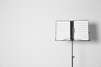 Photo of Note stand with music sheets on white background. Space for text