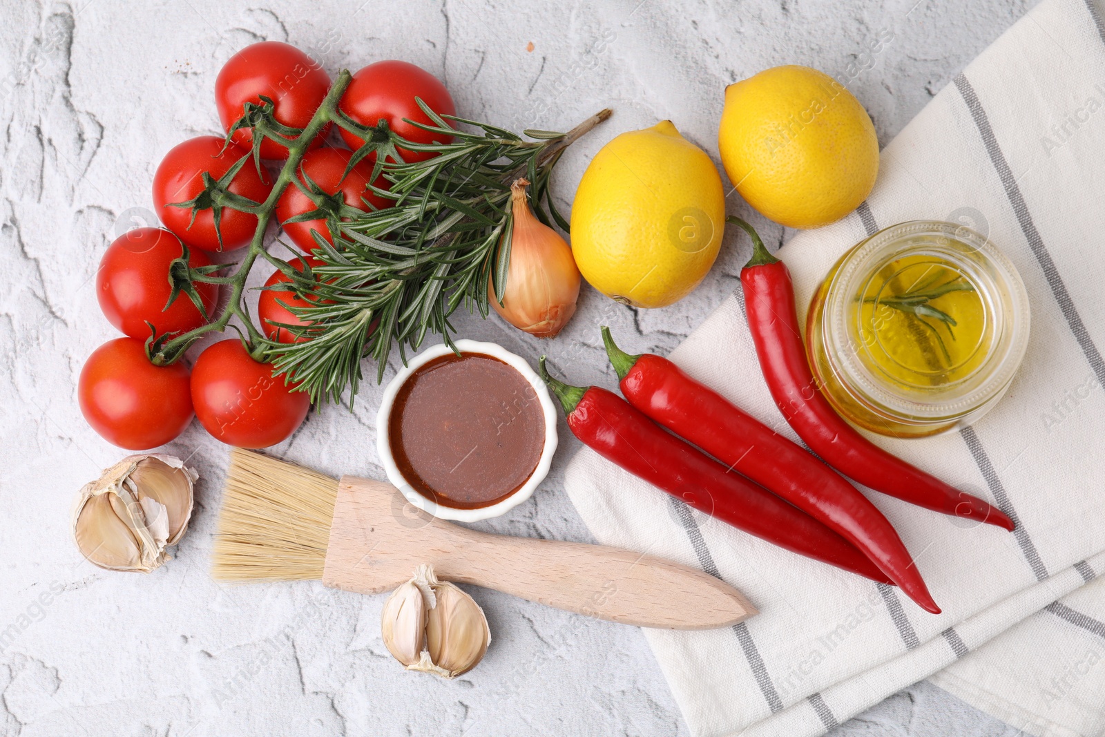 Photo of Fresh marinade, basting brush and different ingredients on light grey textured table, flat lay