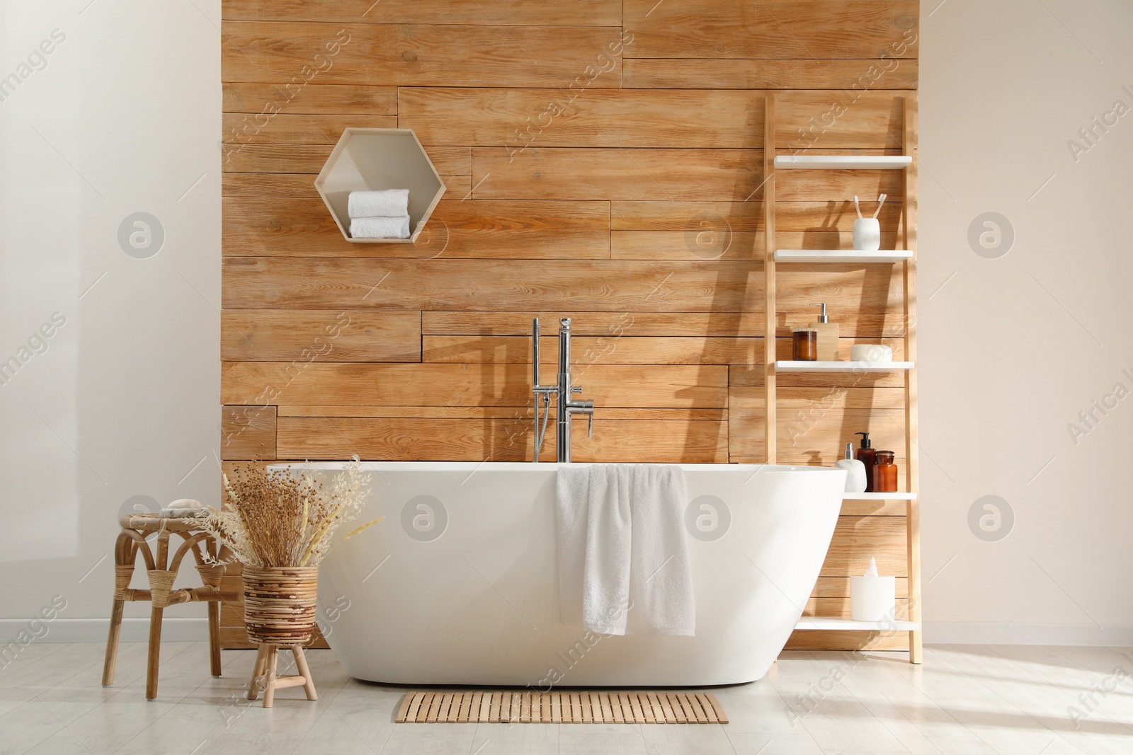 Photo of Bathroom interior with white tub and decor near wooden wall