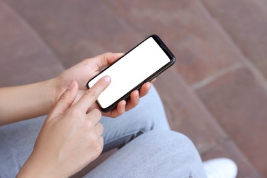 Photo of Closeup view of woman with smartphone sitting outdoors