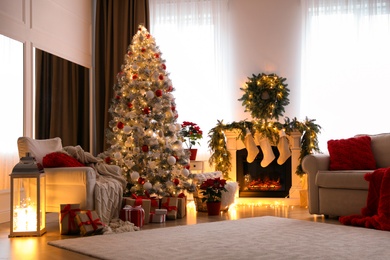 Stylish room interior with fireplace and beautiful Christmas tree