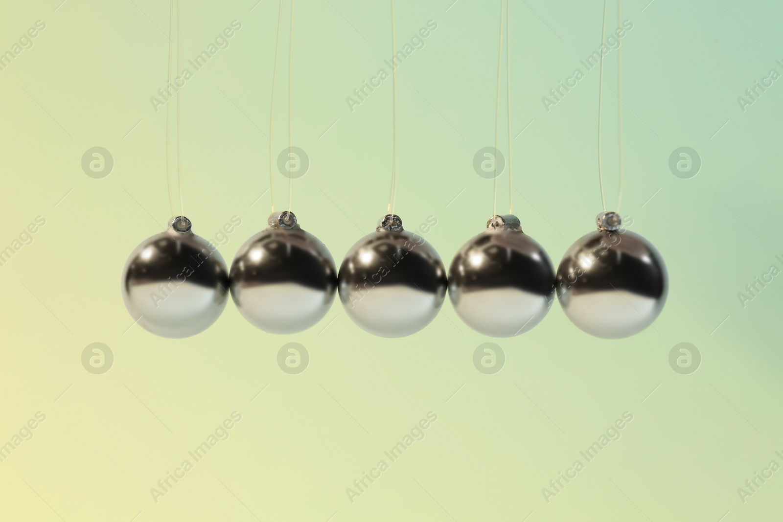 Photo of Newton's cradle on color background. Physics law of energy conservation