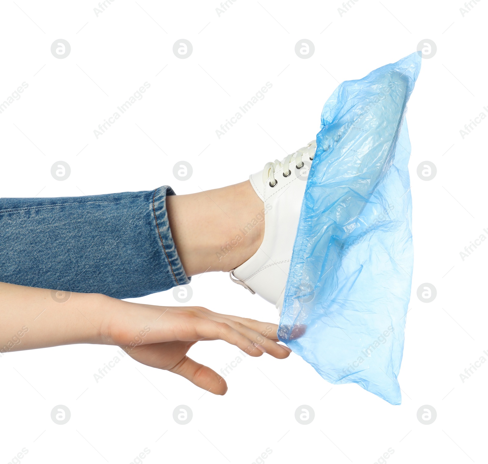 Photo of Woman wearing blue shoe cover onto her sneaker against white background, closeup