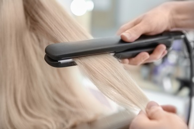 Photo of Professional hairdresser working with client in salon