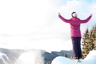 Woman spending winter vacation in mountains. Space for text