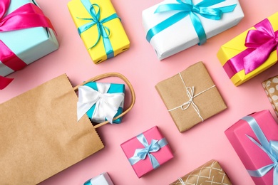 Flat lay composition with shopping bag and gifts on color background