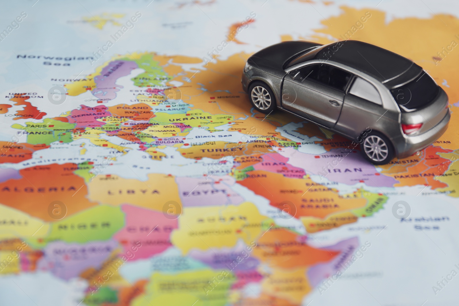 Photo of Grey toy car on world map. Trip planning