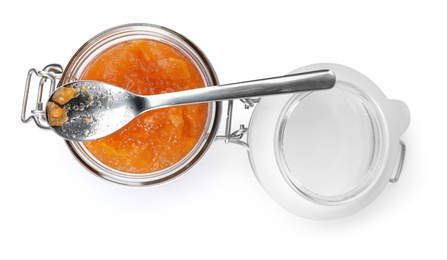 Jar with peach jam and spoon on white background