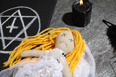 Photo of Bride voodoo doll with pins surrounded by ceremonial items on grey table