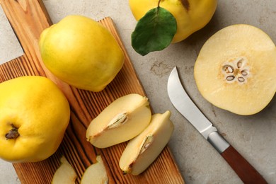 Tasty ripe quince fruits and knife on grey table, flat lay